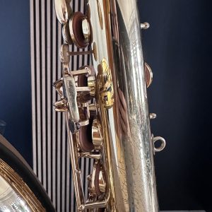 Close-up of shiny brass and silver hardware with rings, bolts, and clamps against a dark background.